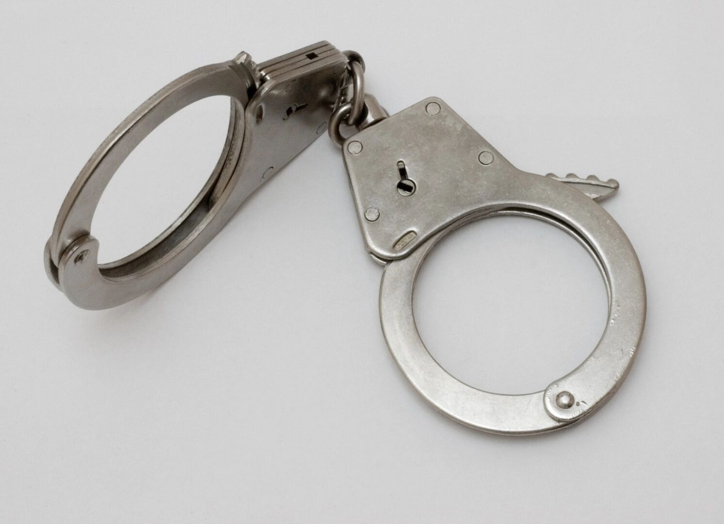 A pair of handcuffs with a key on top.