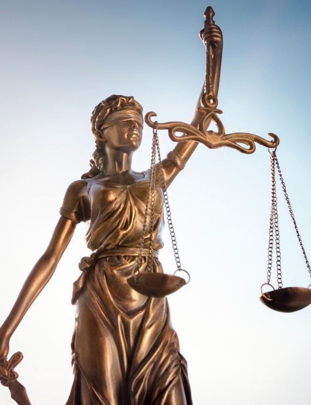 Blindfolded Lady Justice holding balanced scales.