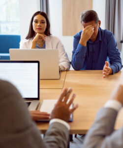 Business meeting with stressed participants and laptops.