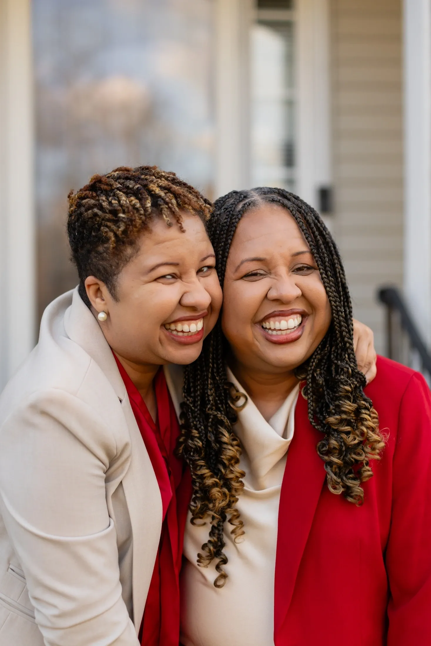 Smiling women embracing in matching outfits.
