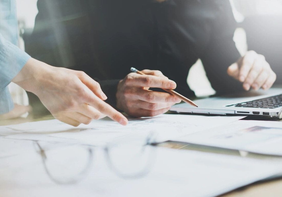 Two people are sitting at a table with papers.