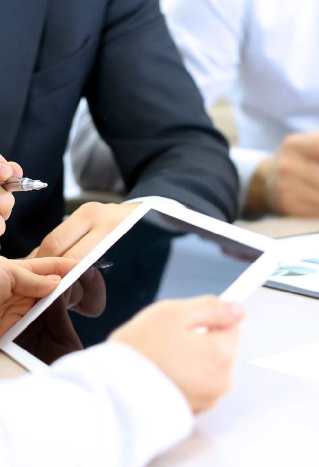 Business meeting with tablet and documents.